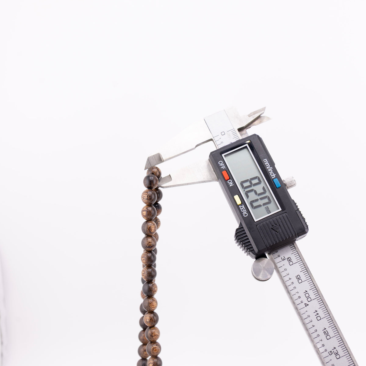 Long agarwood prayer beads with a round wooden bead measured by digital caliper