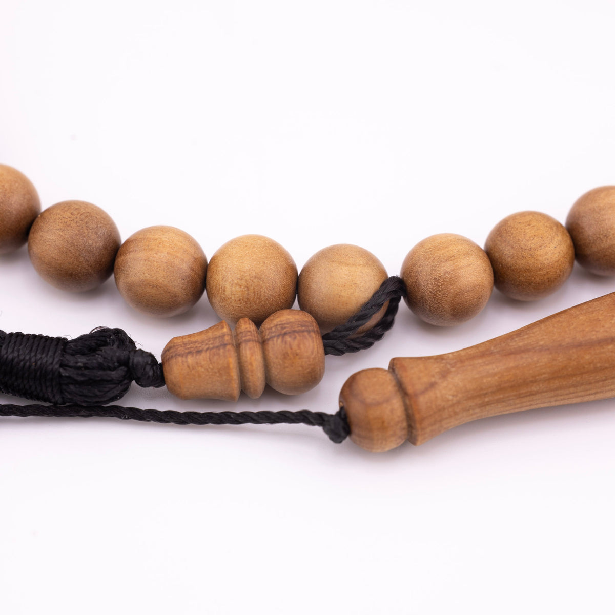 Sandalwood prayer strand for sale shown close up with black cord and carved wooden fittings