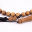 Sandalwood prayer strand for sale shown close up with black cord and carved wooden fittings