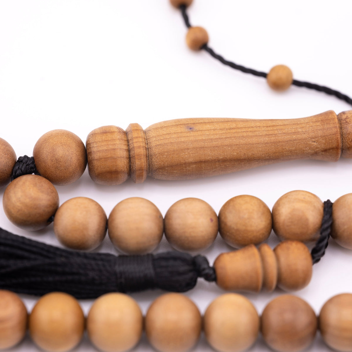 Sandalwood prayer strand for sale showing its long wooden centerpiece and black tassel