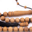 Sandalwood prayer strand for sale showing its long wooden centerpiece and black tassel