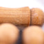 Sandalwood prayer strand for sale in a macro view of the carved centerpiece's wood grain