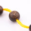 Buy agarwood prayer beads shown in a macro view threaded onto yellow cord