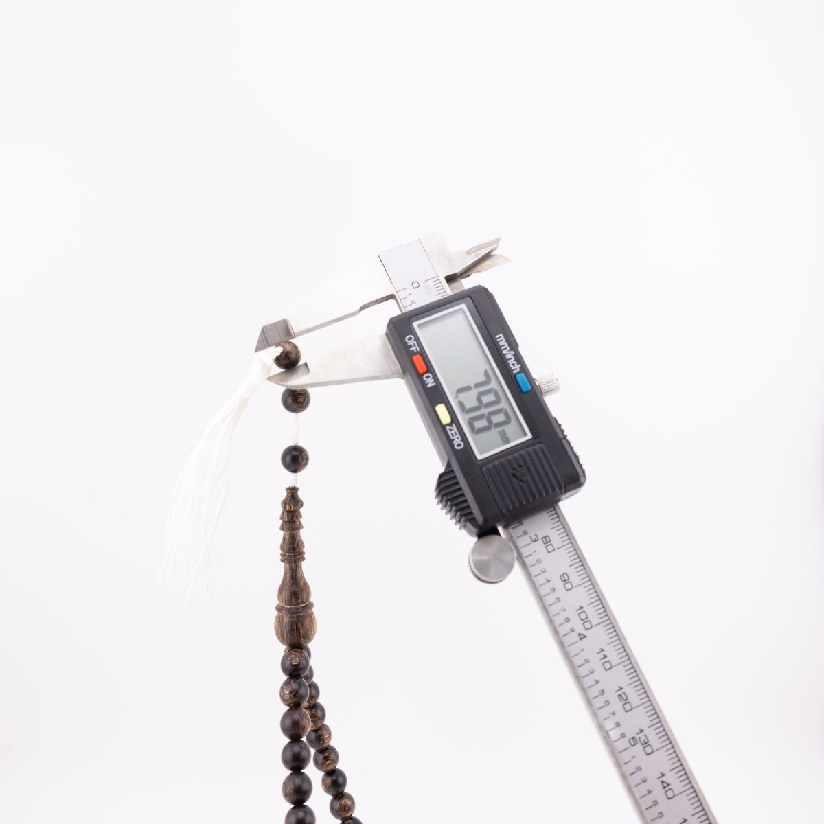Buy agarwood prayer beads with one bead measured beside the white tassel