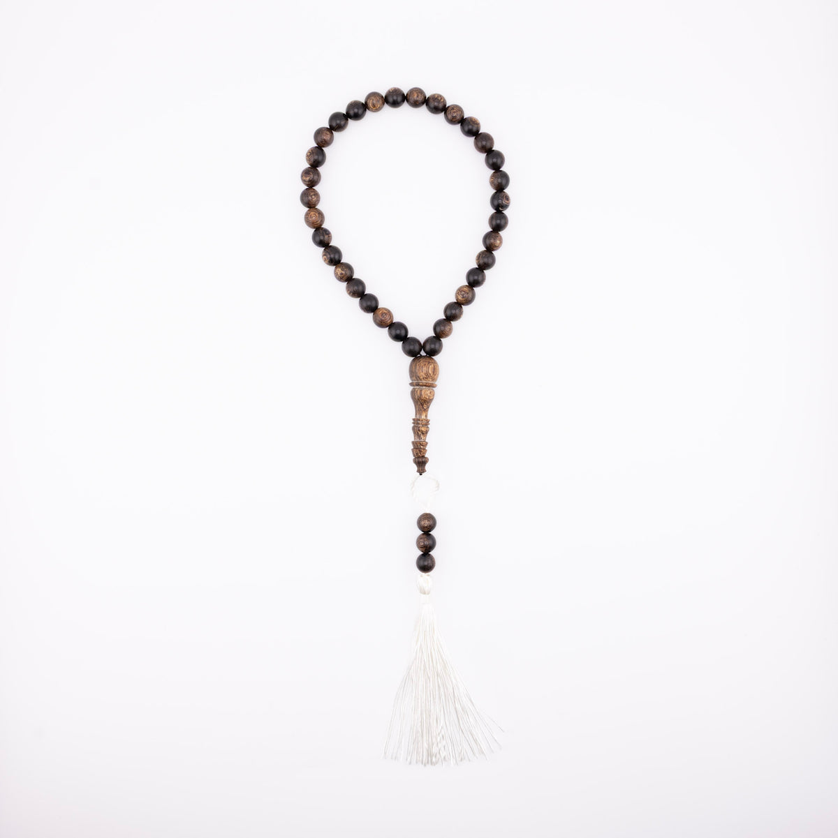 Buy agarwood prayer beads with a white tassel displayed on a white background