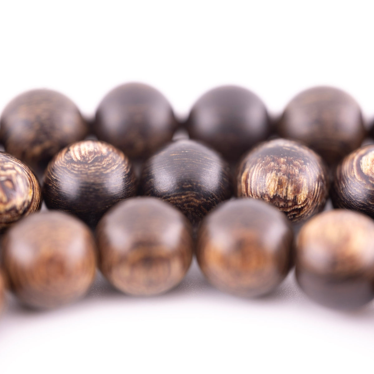 Buy agarwood prayer beads shown in a macro view with varied brown wood grain