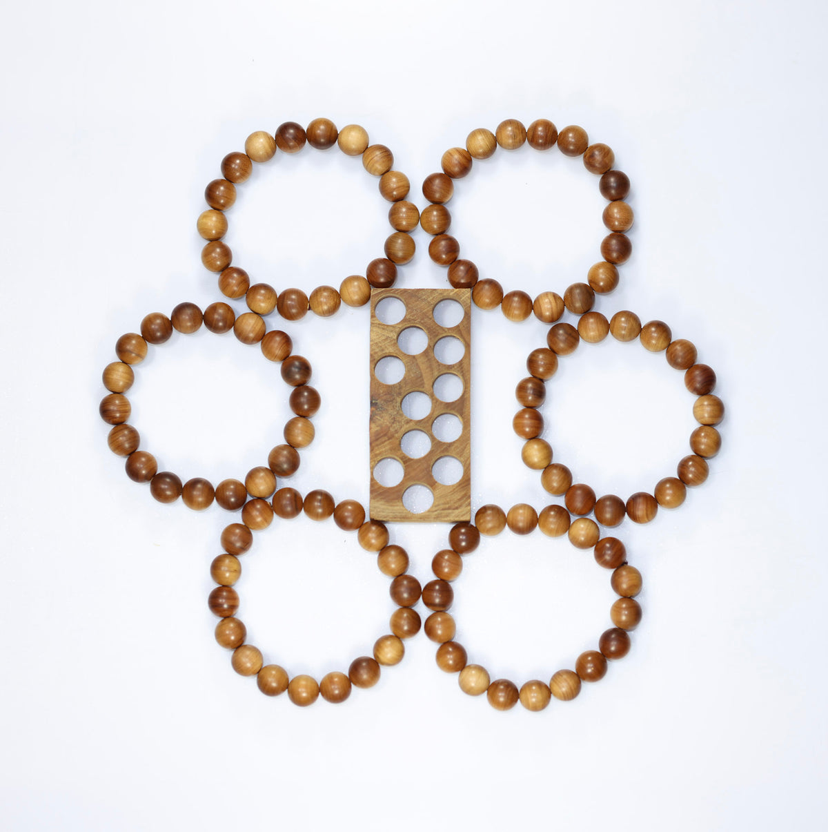 Buy natural sandalwood bracelet collection arranged around a wooden bead-sizing board