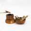 Natural agarwood chips beside a wooden incense heater and metal tongs